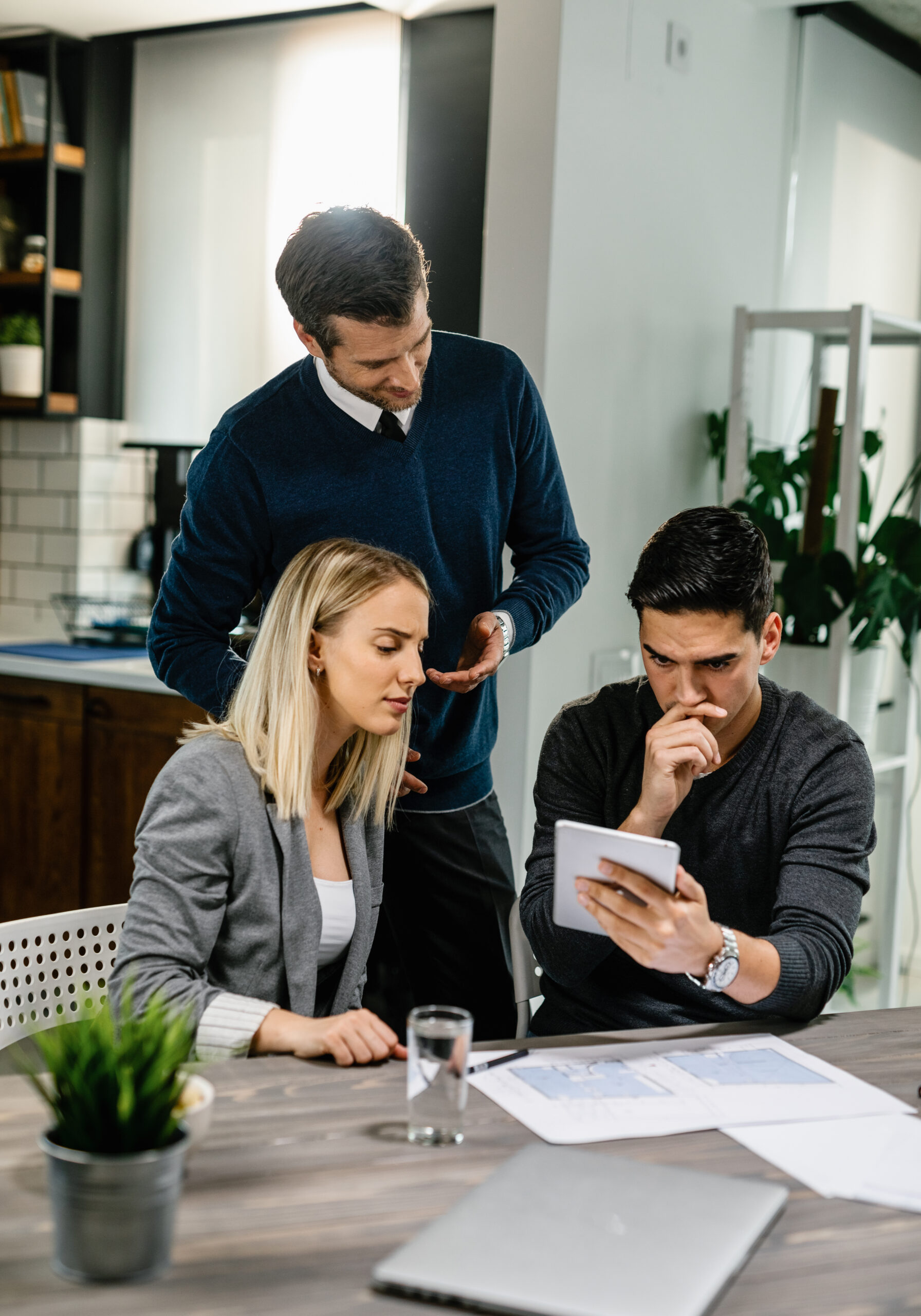 Young couple feeling uncertain while using digital tablet on a meeting with their insurance agent at home.