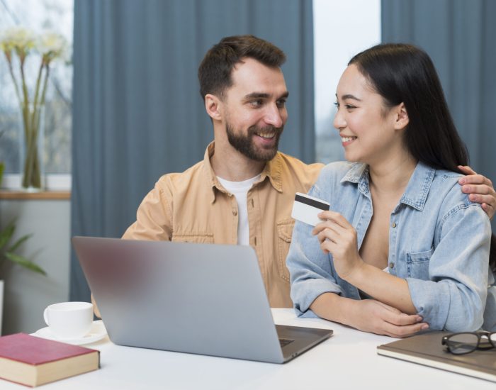 happy-couple-shopping-online-while-desk